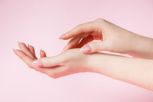 Skin care concept. Beautiful female hands on a pink background. Place for text